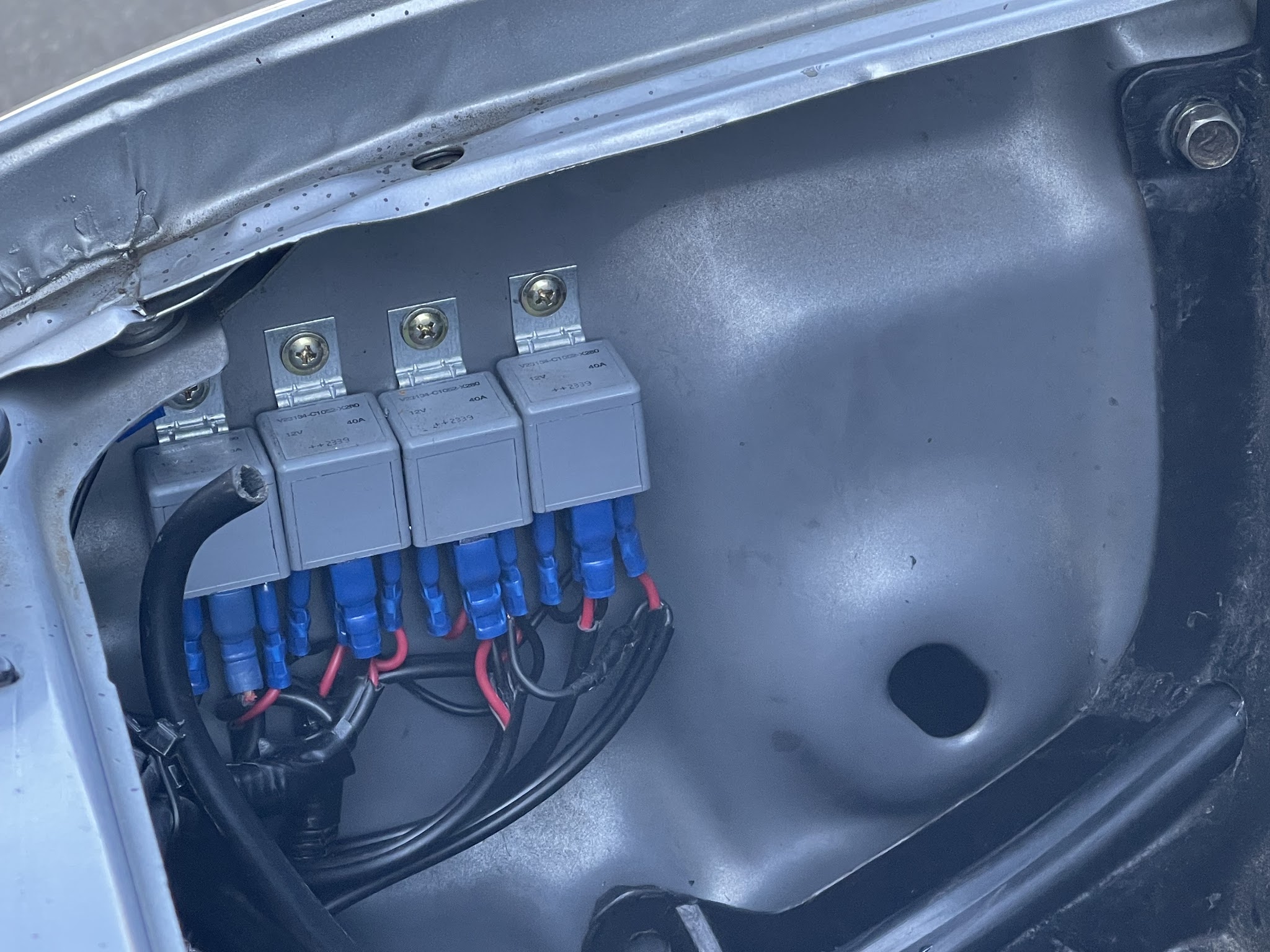 Three new forty amp relays mounted in an engine bay with fresh crimp terminals